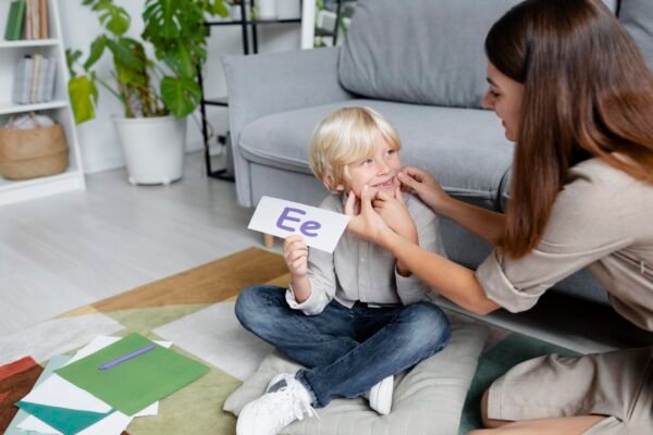 young-woman-doing-speech-therapy-with-little-blonde-boy